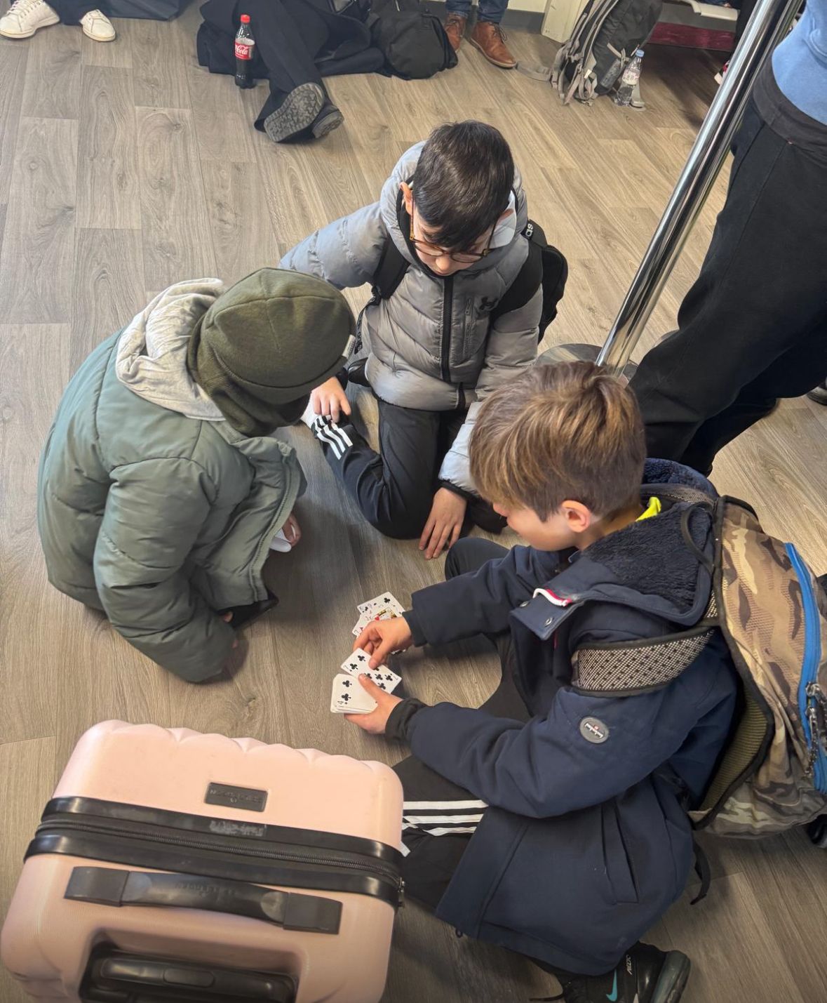 Enfants jouant aux cartes à l'aéroport avant le départ pour l'Écosse