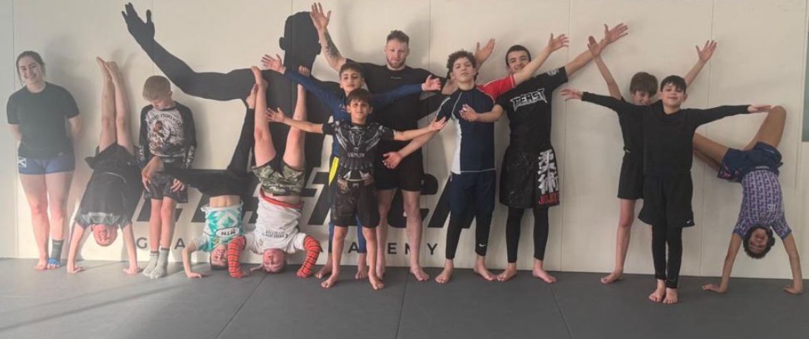 Enfants réalisant des acrobaties contre un mur META-TECH pendant le camp