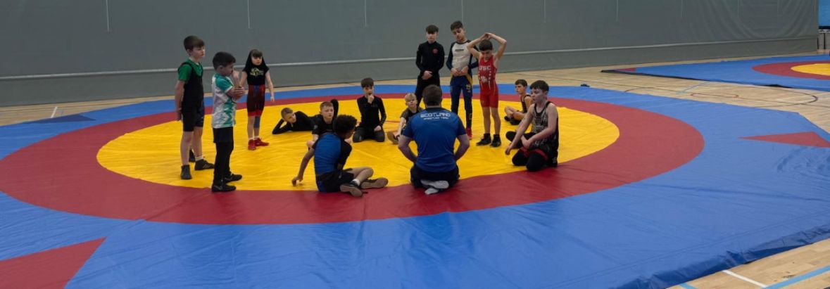 Briefing d'entraînement de lutte sur tapis bleu, rouge et jaune à Largs