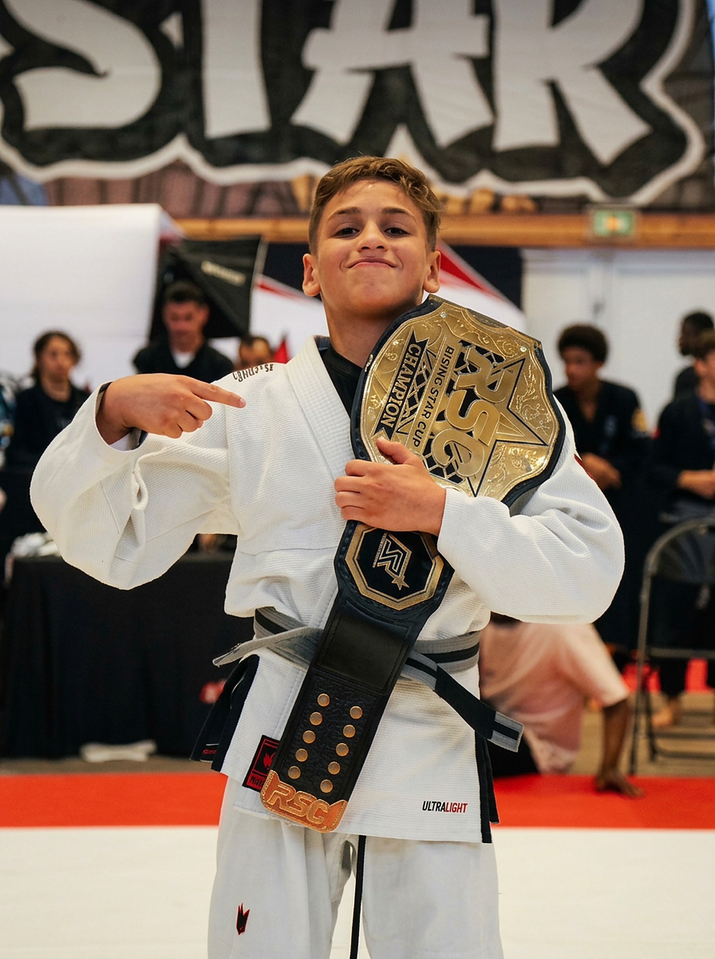 Jeune champion de jiu-jitsu brésilien de Rumi Global avec sa ceinture de champion